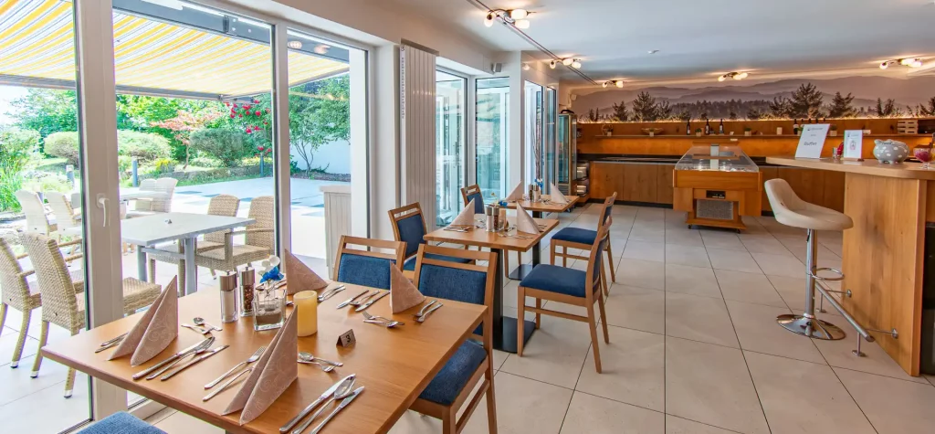 Wellnesshotel Hohenrodt, Restaurant mit Fensterfront und Terrasse, die Sitzmöglichkeiten für ein entspanntes Essen im Freien bietet