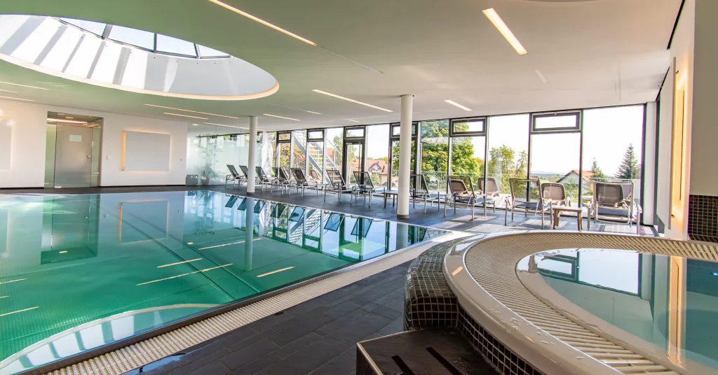 Wellnesshotel Hohenrodt, Wellness-Poolbereich mit Whirlpool, Schwimmbecken und Liegen für erholsame Momente im Wasser